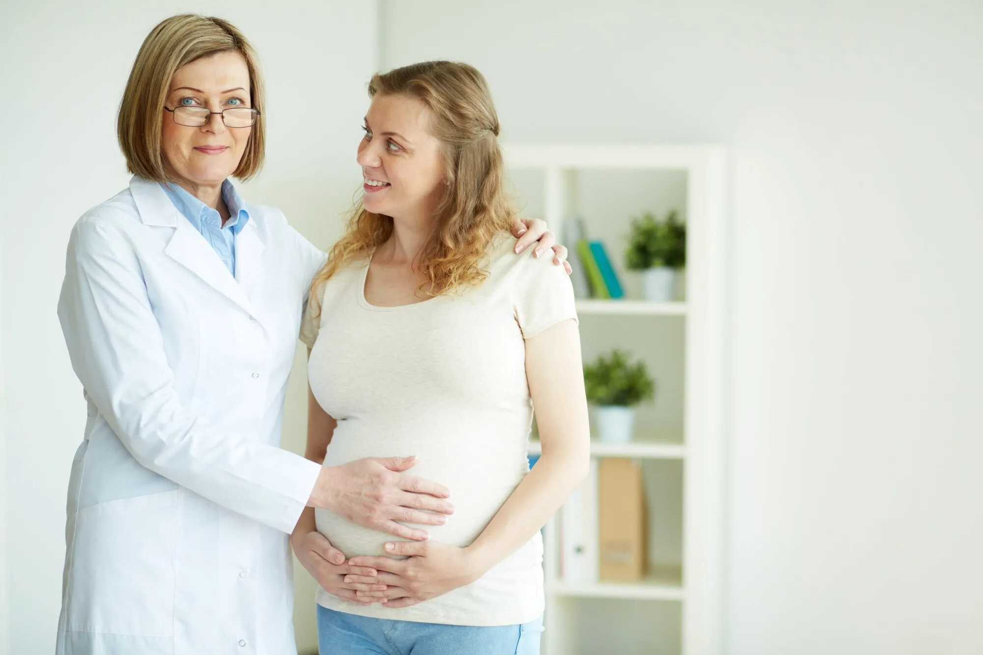 Obstetra conversando con una paciente embarazada en consulta