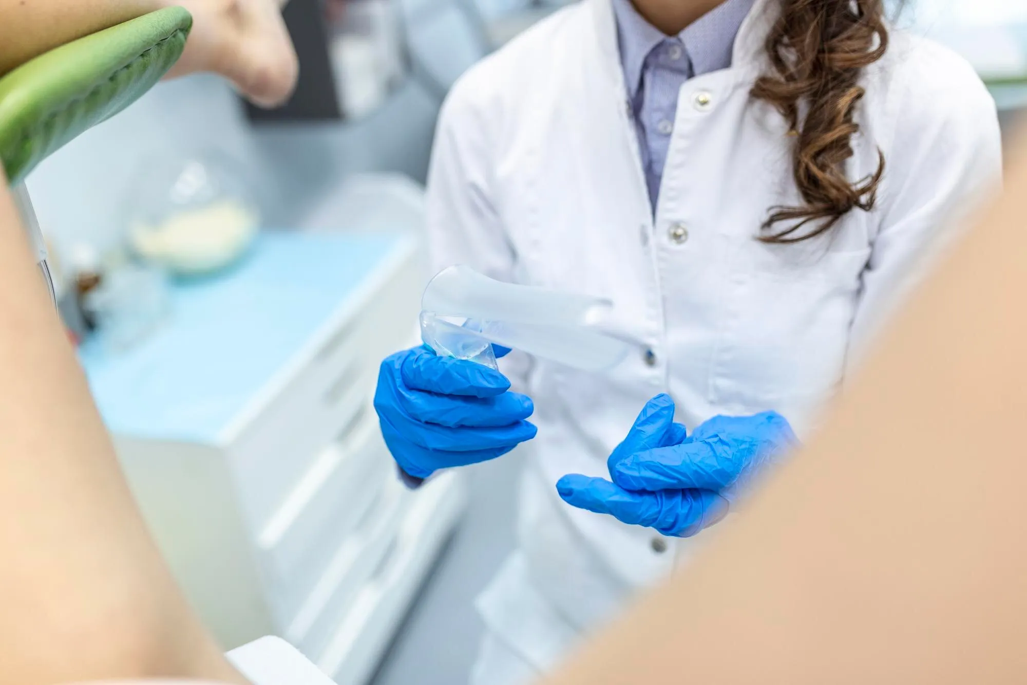 Doctora con guantes preparando una exploración en la consulta